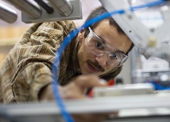 man in plaid shirt working on machinery