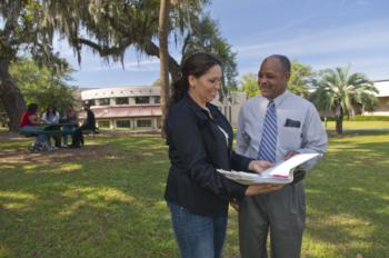 two people discussing over a notebook