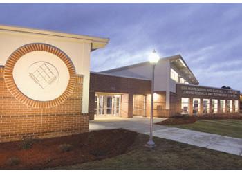 evening view of a building with emblem and lit pathway