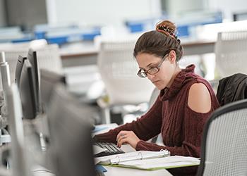 student studying at computers in library