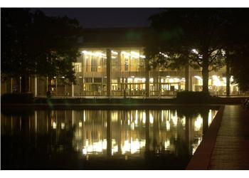 campus building reflected on water at night