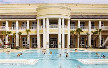 people swimming in outdoor pool with pillars