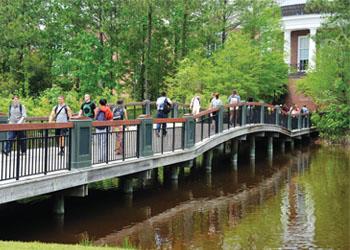 students walking across campus bridge