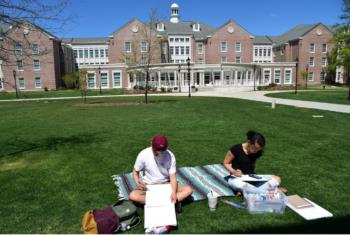 students studying on campus lawn