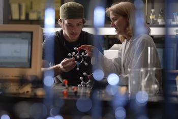 students with a molecular model in a lab