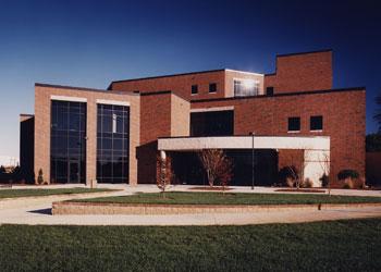 modern academic building with large windows and lawn