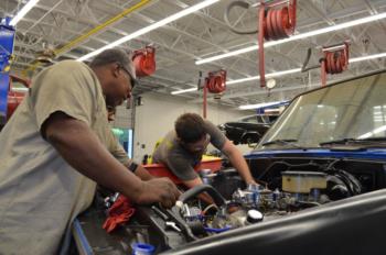 mechanics working on car engine