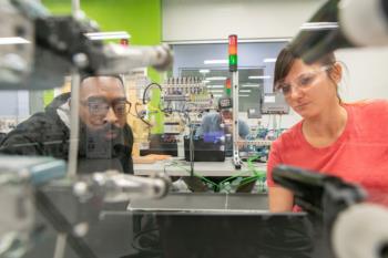 two people examining equipment in a lab