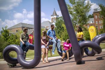 students gathered around campus sculpture