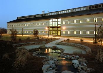 illuminated building exterior at dusk with landscaping